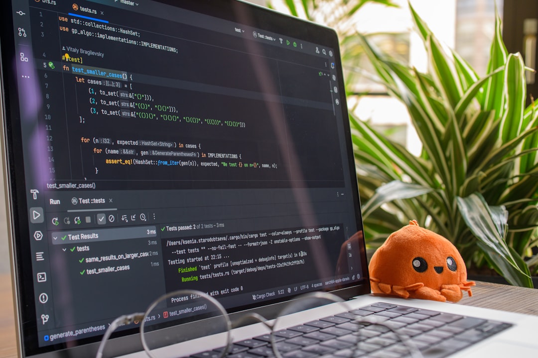 Laptop screen displaying code with a small octopus toy.